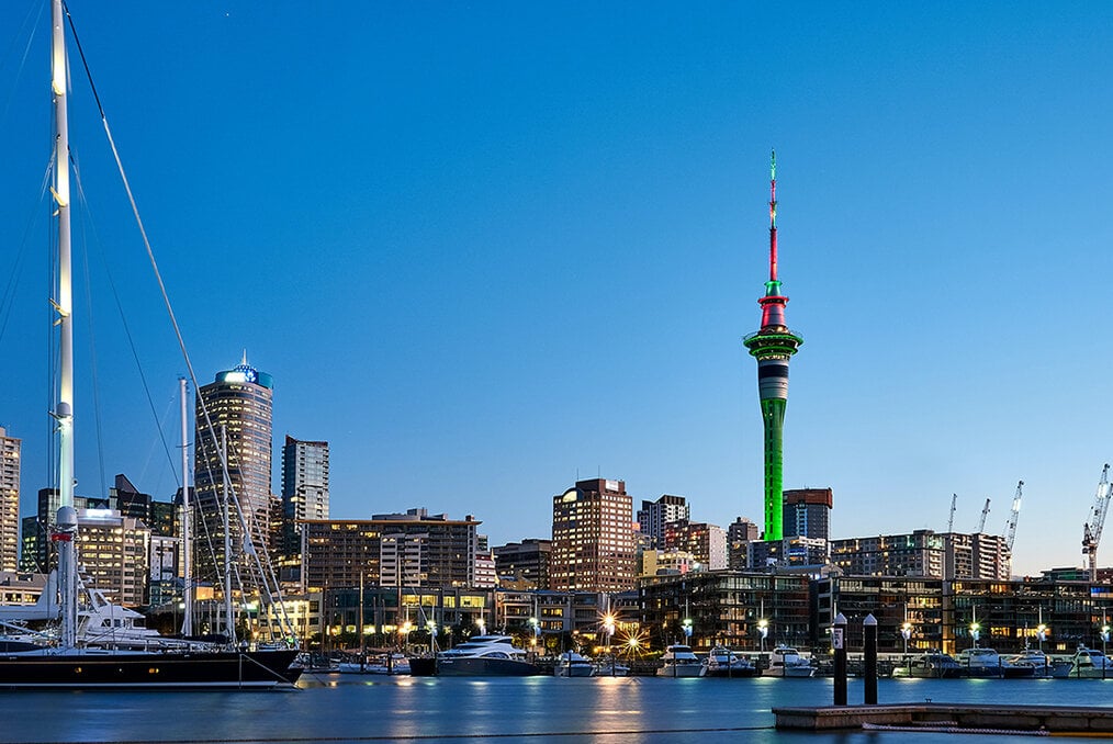 The skyline in Auckland, New Zealand featuring the Skytower let up in green